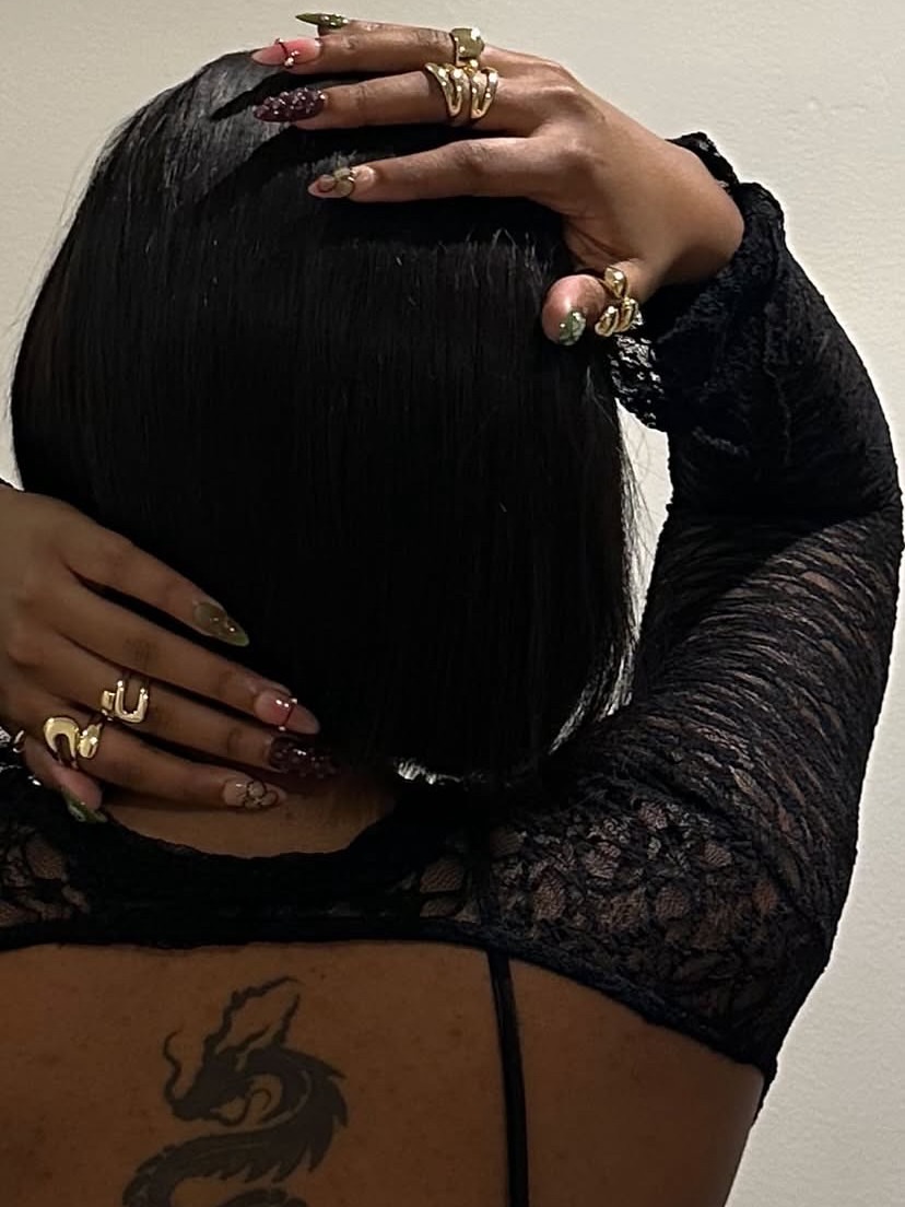 Press-on nail set with gold rings, styled with a dragon back tattoo